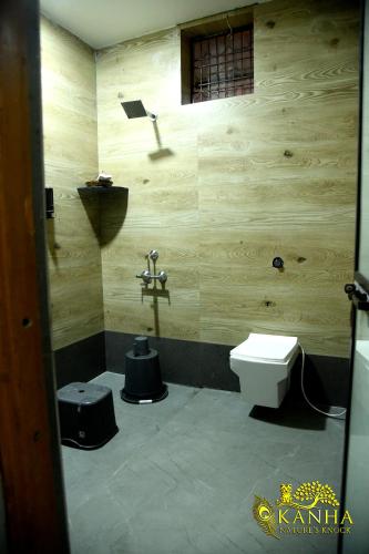 a bathroom with a toilet and a sink at Kanha Nature's Knock in Baihar