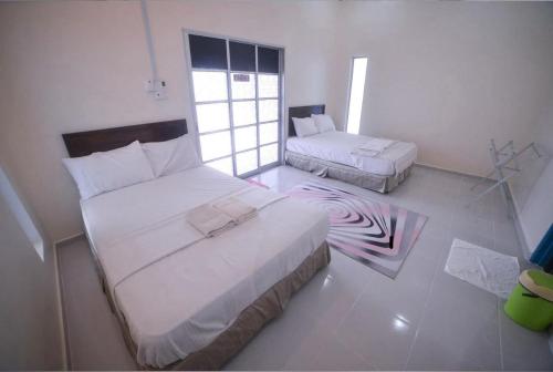 una camera da letto con due letti e un tappeto zebrato di Capital O 91243 Bee Good Chalet a Yan