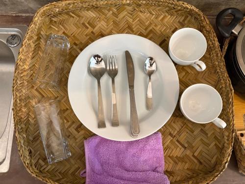 una mesa con un plato blanco con cubiertos encima en Villa Komalee, en Unawatuna