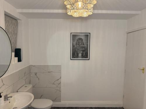 ein Badezimmer mit Toilette, Waschbecken und Kronleuchter in der Unterkunft City Centre 2 Bed with Ensuite Rooms Wakefield in Wakefield