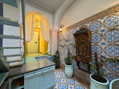 eine Küche mit blauen und weißen Fliesen an der Wand in der Unterkunft La Petite Maison - Dar El Bacha in Marrakesch