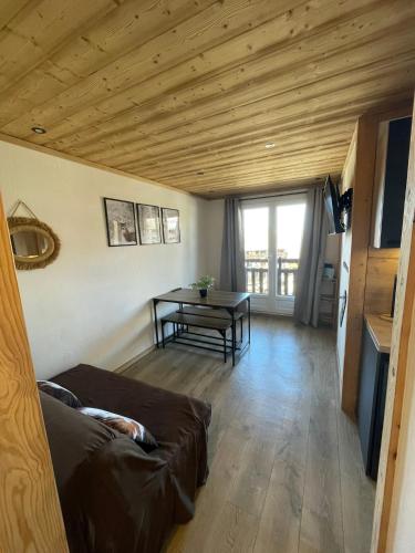 un salon avec un canapé et une table dans l'établissement Risoul 1850 studio Résidence LesFlorins2 pour 4 pers avec accès direct sur les pistes, à Risoul
