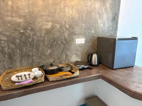 una cocina con encimera con microondas y nevera en Villa Komalee, en Unawatuna