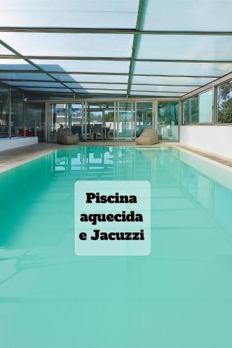 a swimming pool with a sign in a building at Fonte Seca GuestHouse in Leiria