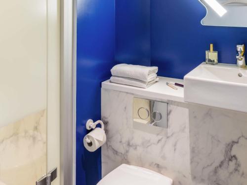 Un baño con lavabo blanco y inodoro. en ibis budget Senlis, en Senlis