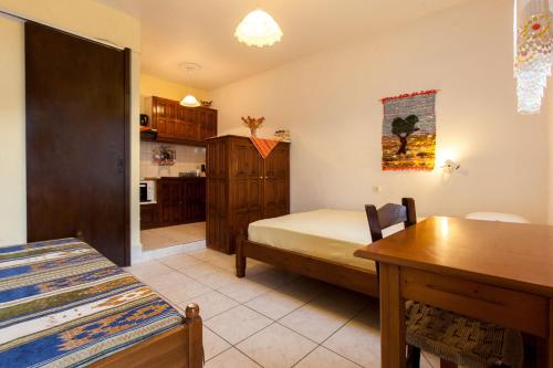 a bedroom with a bed and a table and a kitchen at Nikoleri Studios & Apartments in Lefokastro