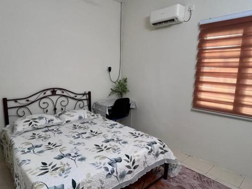 a bedroom with a bed with a blue and white comforter at Lakeville Inn in Seri Iskandar