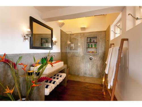 a bathroom with a shower and a sink and a mirror at Pool, Roof Terrace, 3 Bedroom Villa, Galle Fort in Galle