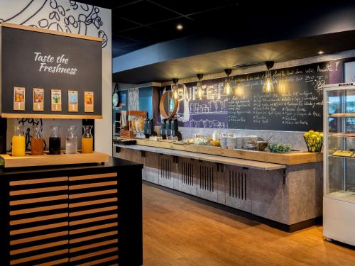 un restaurante con una barra con un menú en la pared en ibis Budget Paris La Villette 19ème, en París