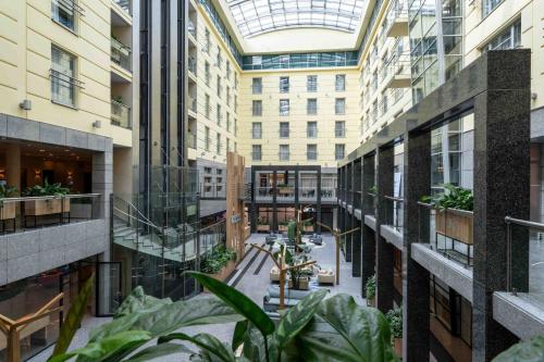 an indoor courtyard in a building with plants at Wyndham Wroclaw Old Town in Wrocław