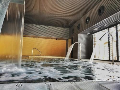 a hot tub with a water fountain in a room at Panoramic Suites Burbuja junto al Puy du Fou y Toledo in Guadamur
