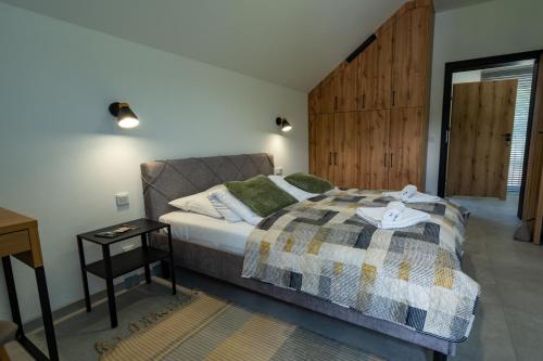 a bedroom with a bed and a wooden wall at Nowa Osada in Łącko