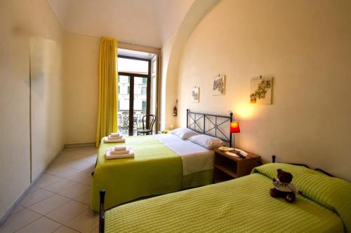 a bedroom with two beds and a window at Il Giardino di Tonia - Oplontis Guest House - Bed & Garden - in Torre Annunziata