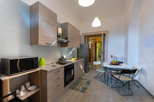 eine Küche mit einem kleinen Tisch und einer Mikrowelle in der Unterkunft Il Giardino di Tonia - Oplontis Guest House - Bed & Garden - in Torre Annunziata