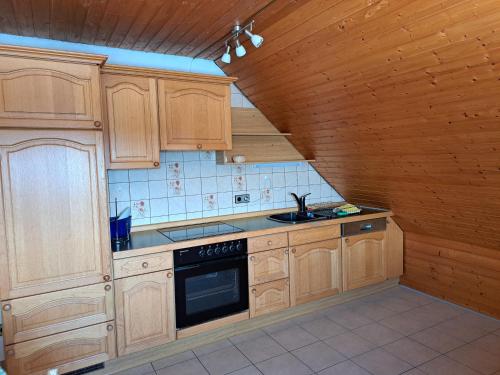 a kitchen with wooden cabinets and a sink at Blick in den Hegau in Engen