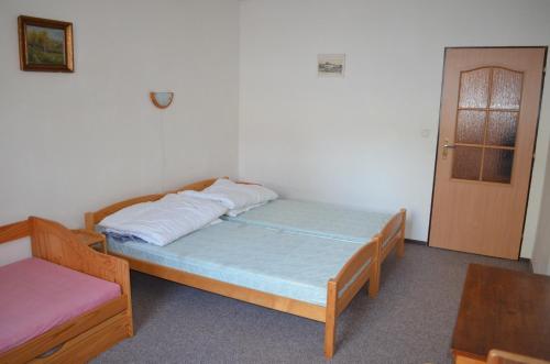 a small bedroom with a bed and a door at Penzion Gerle in Cerny Dul