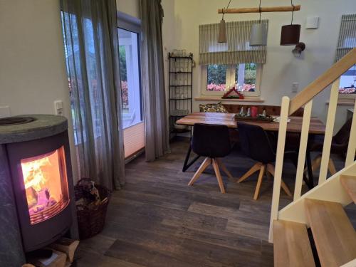 a living room with a table and a fireplace at Haus Swanhild in Fockbek