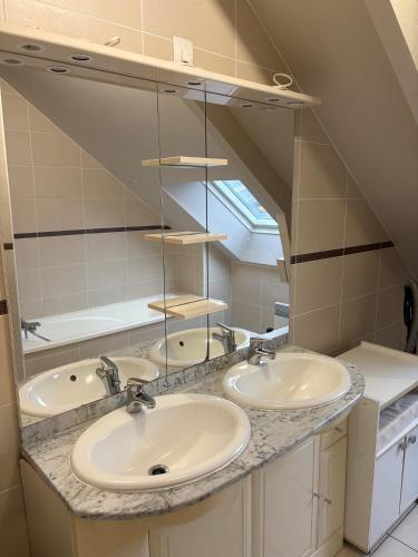 une salle de bain avec trois lavabos et un miroir dans l'établissement Le Chêne, à Baguer-Pican