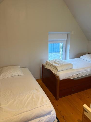 deux lits jumeaux dans une chambre avec fenêtre dans l'établissement Le Chêne, à Baguer-Pican