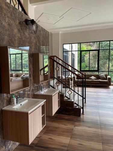a bathroom with two sinks and a staircase with windows at فيلا جولدن فلور بونشاك in Tagalbato
