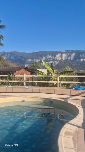 une grande piscine avec une montagne en arrière-plan dans l'établissement La Corbassière, à Murs-et-Gélignieux