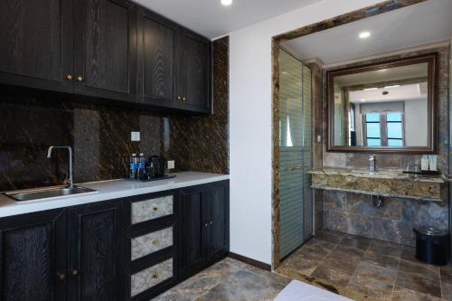 a kitchen with a sink and a mirror at The Nice Hotel Phu Quoc - Fireworks & Ocean view in Phu Quoc