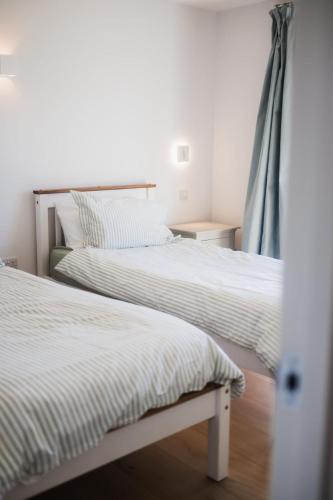 two beds sitting next to each other in a bedroom at Putsborough Cottage in Croyde