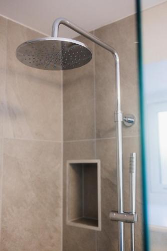 a shower with a shower head in a bathroom at Putsborough Cottage in Croyde