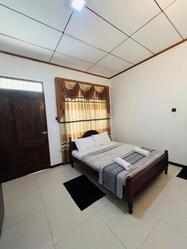 a bedroom with a bed and a window at Ella Bungalow in Ella