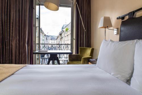 a hotel room with a bed and a balcony at Eastwest Hôtel by Malone in Geneva