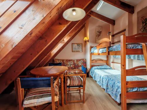 a bedroom with a bunk bed and a desk and a table at Dúplex rústico familiar- Amplitud y vistas espectaculares - Cuc 2 in Pla de l'Ermita