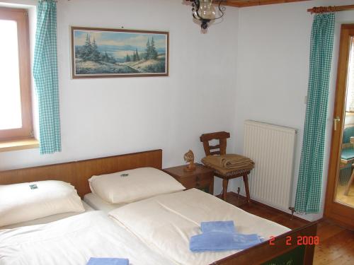 ein Schlafzimmer mit zwei Betten und einem Stuhl in der Unterkunft Gruppenhaus Hirzhof in Auberg