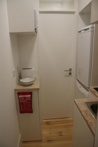 a small kitchen with a white refrigerator and a sink at VR Martim Moniz in Lisbon