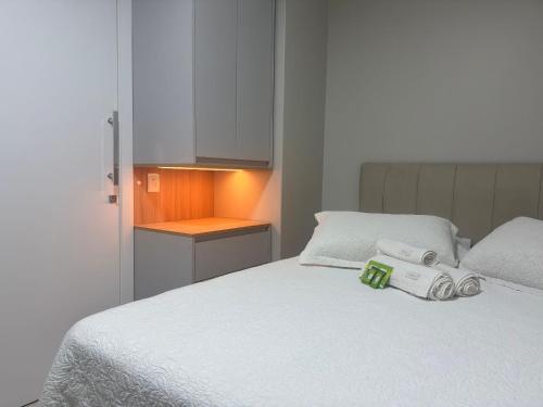 una camera da letto con un letto bianco con due asciugamani sopra di Camarote da Moacir !!!! a Capão da Canoa