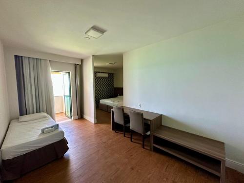 a bedroom with a bed and a desk and a table at Recife Mar Flats Hotel in Recife