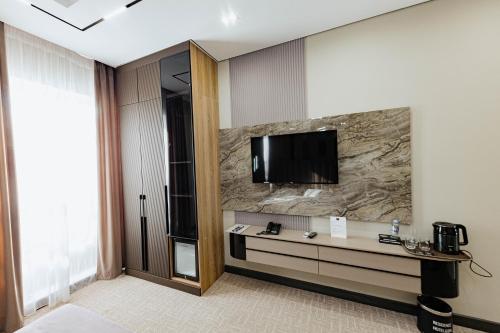 a hotel room with a television on a wall at Residence Hotel Spa in Taraz