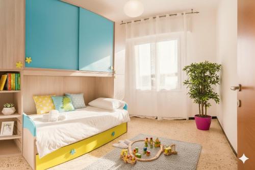 een kinderkamer met een bed en een groot raam bij Perla d'aMare in San Lorenzo al Mare