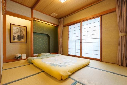 a bedroom with a bed in a room with windows at Just a short walk 心斎橋 Glico Sign 1min 道頓堀30-second 黒門市場 難波駅 Dotonbori Guesthouse 兰の阁 in Osaka