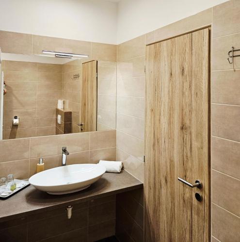 a bathroom with a sink and a mirror at Mediterrán Villa Kecskemét in Kecskemét