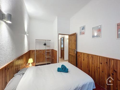 une chambre avec un lit avec une serviette bleue dessus dans l'établissement Easy House - Climatisation - 1 min Vieux Port, à La Ciotat