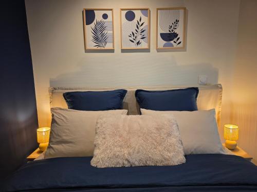 a bedroom with a bed with three pictures on the wall at Duplex avec baignoire balnéo à 10 min de Strasbourg in Schiltigheim