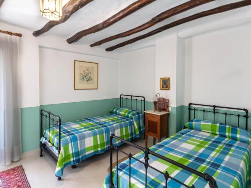 two beds in a room with green and white walls at Casa Mirador de Murchas in Murchas