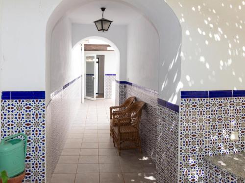 a bathroom with blue and white tiles and a chair at Casa Mirador de Murchas in Murchas