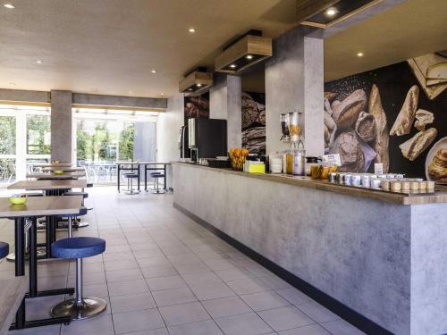 ein Restaurant mit einer Theke und einigen Tischen und Stühlen in der Unterkunft ibis budget Arles Sud Fourchon in Arles