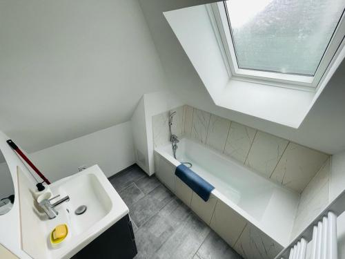 une salle de bain blanche avec un lavabo et une baignoire dans l'établissement Maison cosy Jardin des Plantes - 9 voyageurs - 388, à Rouen