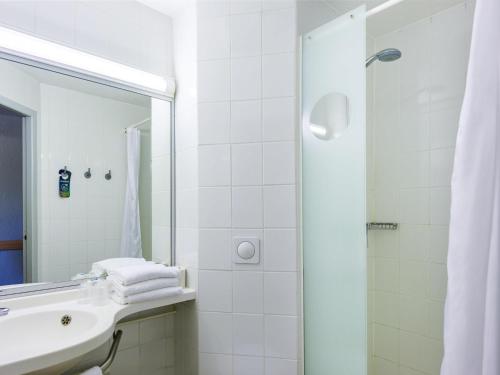 Un baño blanco con lavabo y ducha en Ibis Budget Avignon Nord, en Le Pontet