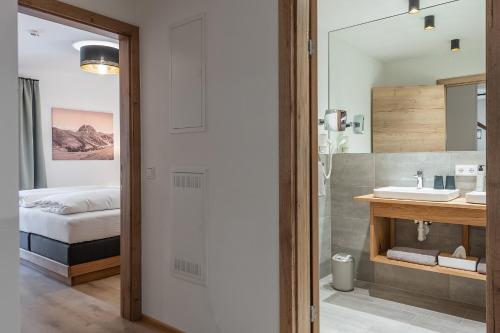 Una cama o camas en una habitación de AlpenParks Hotel & Apartment Taxacher