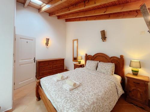 a bedroom with a bed with two towels on it at Casa Roma in Raposeira