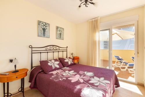 a bedroom with a bed and a table and a balcony at Beachfront penthouse in La Manga in San Blas