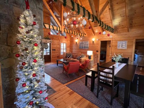 a christmas tree in the living room of a cabin at Holiday Hideaway - Fire Pit, Hot Tub & Mountain Magic in Ellijay